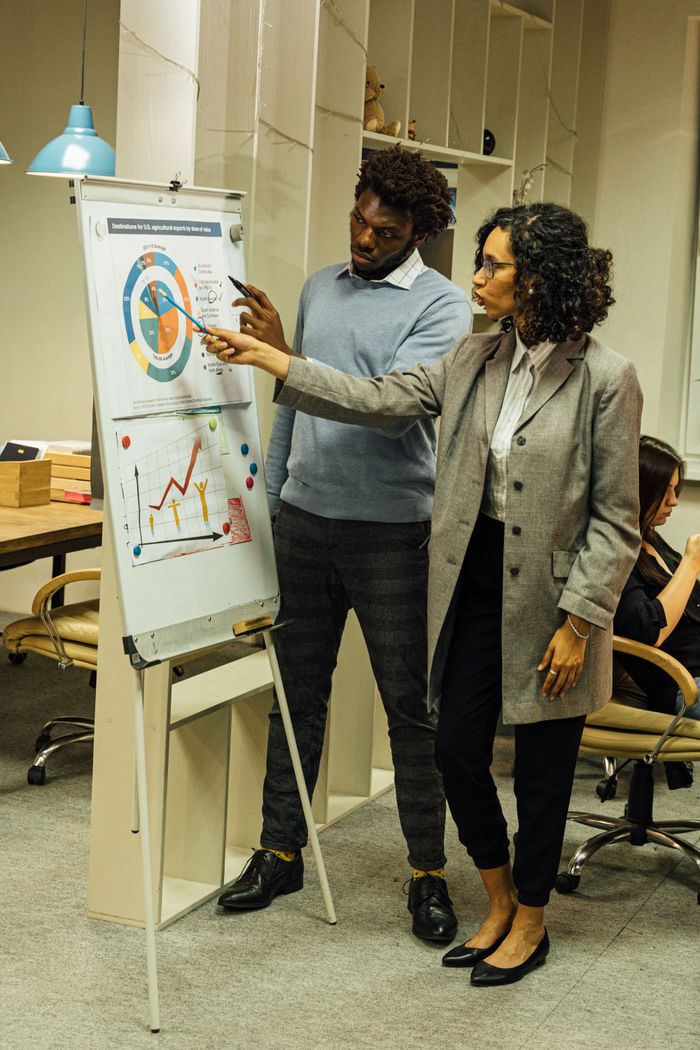 services-02 Colleagues engage in data analysis discussion during a team meeting in a contemporary office space.